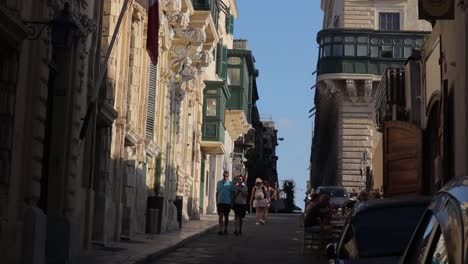 Eine-Langsame-Aufnahme-Einer-Erstaunlichen-Engen-Straße-In-Malta,-Mit-Einwohnern-Und-Touristen