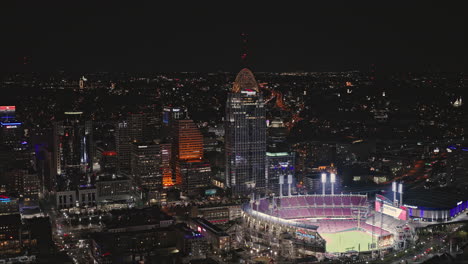 Toma-Aérea-De-Un-Dron-Sobrevolando-El-Río-Con-El-Great-American-Ball-Park-Y-El-Paisaje-Urbano-Del-Centro-Iluminado-Por-La-Noche-En-Cincinnati,-Ohio,-Tomada-Con-Inspire-3-8k---Septiembre-De-2023