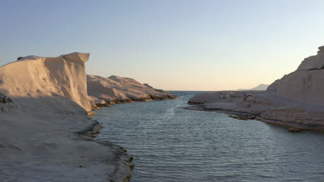 Aerial:-Low-flight-in-Sarakiniko-beach-of-Milos-island,-Cyclades,-Greece-during-sunrise