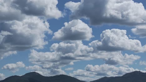 Filming-with-a-drone-in-167mm-the-passage-of-a-large-group-of-beautiful-white-clouds-with-shadows-in-the-lower-parts-in-a-striking-blue-sky-with-its-peculiar-cottony-shapes,-the-recording-is-relaxing