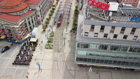 Drone-shot-reveals-Market-Square-in-Katowice,-a-cityscape-with-apartment-buildings,-tram-stop