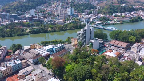 Sunny-Aerial-view-of-the-Ataulpho-Pinto-dos-Reis-bridge-and-Centenário-Jardim-da-Preguiça-Park-in-Barra-Mansa,-Rio-de-Janeiro,-Brazil