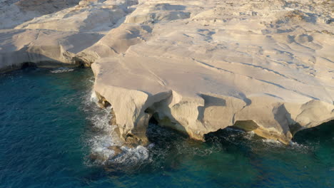 Aerial:-Panoramic-orbit-shot-of-Sarakiniko-beach-in-Milos-island,-Cyclades,-Greece-during-sunrise