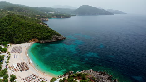 Aerial-drone-shot-of-Greek-Landscape-with-Turquoise-Sea-or-Ocean-Bay-and-Empty-Sand-Beach