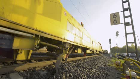 Blurred-motion-of-a-yellow-Deutsche-Bahn-train-moving-on-tracks,-dynamic-daylight-shot