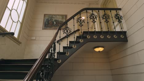 Unas-Viejas-Escaleras-De-Madera-Se-Inclinan-Hacia-Una-Lámpara-De-Araña-En-Un-Edificio-Antiguo-Histórico-Y-Hermoso.