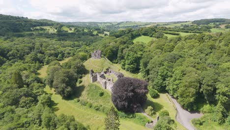 Aerial-view-of-Okehampton-Castle-surrounded-by-lush-greenery-in-Devon,-UK