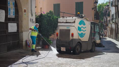 Public-street-cleaning-serviceman-use-high-water-pressure-equipment,-Mallorca