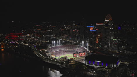 Cincinnati-Ohio-Aerial-v40-flyover-the-river-capturing-waterfront-downtown-cityscape,-baseball-game-playing-in-the-ball-park-and-freeway-traffic-at-night---Shot-with-Inspire-3-8k---September-2023