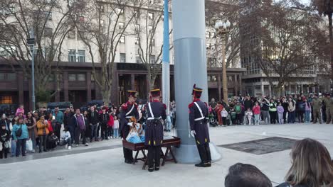 Toma-Panorámica-En-La-Plaza-De-Mayo-De-Oficiales-Militares-Bajando-La-Bandera-Argentina-En-Medio-De-Ciudadanos-Que-Observaban-El-Espectáculo.