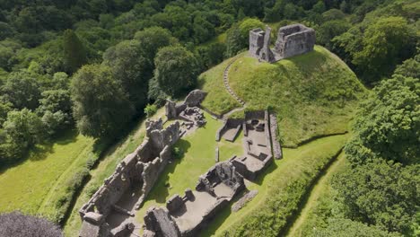 Drone-fly-out-showcasing-Okehampton-Castle-and-surrounding-landscape-in-Devon,-UK