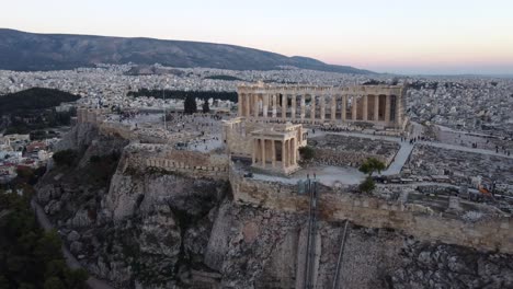 Vista-Aérea-Que-Muestra-La-Inclinación-Del-Monumento-Del-Partenón,-Colina-De-La-Acrópolis-De-Atenas-Al-Atardecer,-Grecia