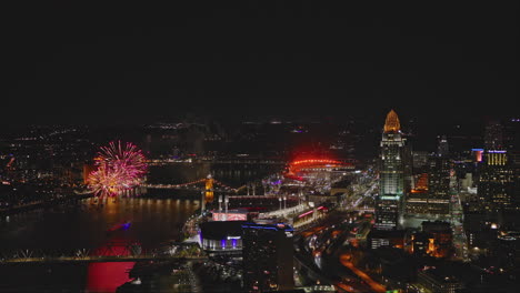 Cincinnati-Ohio-Aerial-v43-flyover-captures-riverfront-stadiums,-illuminated-downtown-cityscape,-views-of-Covington-with-river-fireworks-illuminating-the-sky---Shot-with-Inspire-3-8k---September-2023