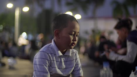 Young-child-mesmerised-by-plastic-bottle,-entertaining-Indonesian-kid