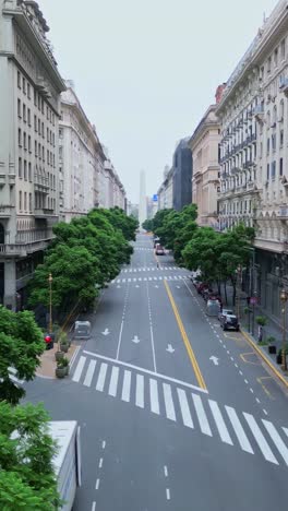 Aerial-zoom-out-view-of-Diagonal-Norte-Street,in-Buenos-Aires,-Argentina-on-a-beautiful-cloudy-sky