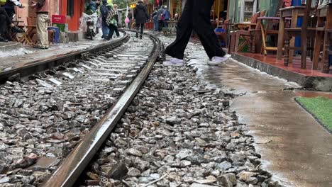 Hanoi-Bahnstraße,-Vietnam---Frau-Tritt-Auf-Die-Gleise,-Um-Ein-Foto-Aus-Niedriger-Perspektive-Von-Den-Top-10-Reisezielen-Zu-Machen