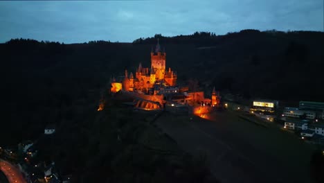 Vista-Aérea-Con-Drones-Del-Castillo-De-Cochem,-Renania-Palatinado,-Alemania,-En-Un-Hermoso-Cielo-Nocturno-Nublado