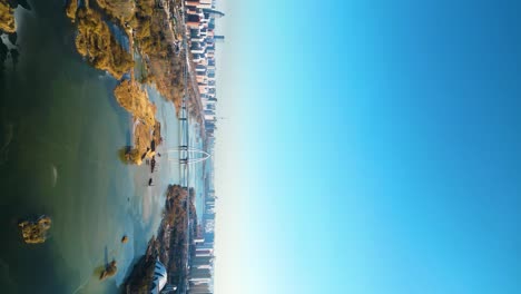 A-vertical-aerial-view-captures-a-bridge-with-car-traffic,-spanning-the-Benghe-River-in-downtown-Linyi,-Shandong-Province,-China