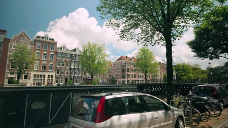 Bilderdijkkade-travel-in-Amsterdam-city-centre-with-views-of-canal-houses,-boat-houses,-and-parked-cars