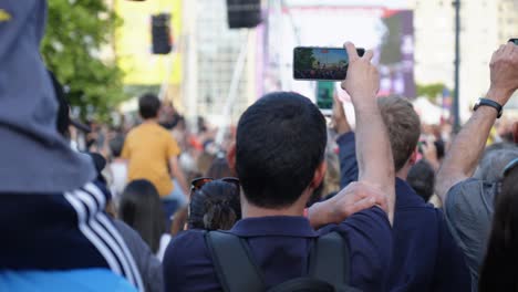 Toma-En-Cámara-Lenta-De-La-Multitud-Que-Graba-El-Relevo-De-La-Antorcha-Olímpica-De-París-2024