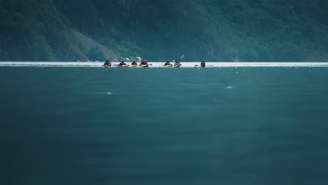 Un-Grupo-De-Kayakistas-Disfrutando-Del-Fiordo-De-Naeroy,-Sus-Barcos-Moviéndose-Con-Las-Olas.