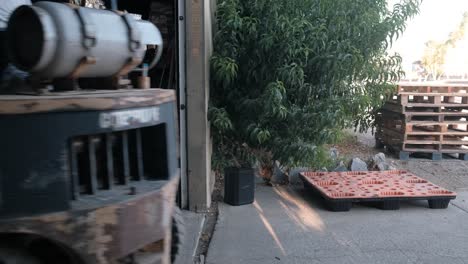 Man-on-forklift-passing-by-with-a-full-pallet-into-a-warehouse