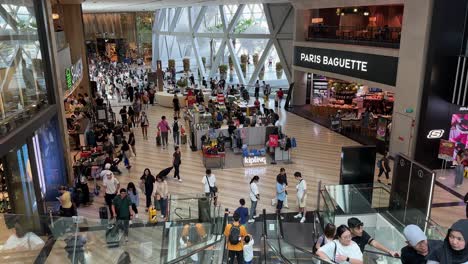 Jewel-Singapore-Changi-Airport-Shopping-Complex-Fährt-Rolltreppen-Hinunter,-Weitwinkelaufnahme,-Schwenk-Nach-Links