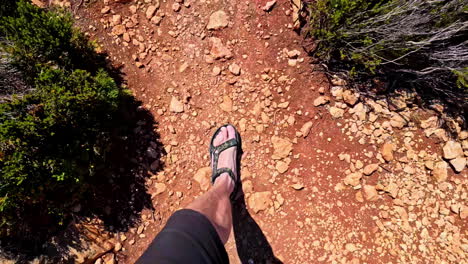 Top-Down-POV-Aufnahme-Eines-Mannes-In-Shorts,-Der-Auf-Einer-Rauen-Oberfläche-Des-Navagio-Pludmale-In-Griechenland-Läuft