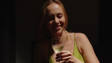 A-beautiful-girl-dressed-in-sexy-lingerie-laughs-and-smiles-while-holding-a-glass-of-white-wine