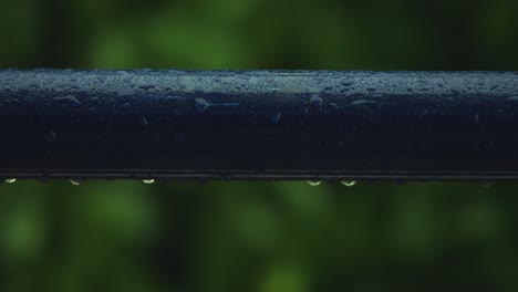 Rain-drops-forming-on-blue-pipe-due-to-heavy-rain