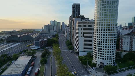 Aerial-zoom-in-view-of-9-de-Julio-Avenue,-Retiro-Train-Station-in-Buenos-Aires,-Argentina-on-a-beautiful-cloudy-sky