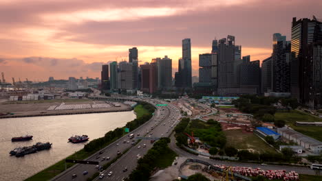 Beautiful-golden-sky,-silhouette-buildings,-city-road-network,-aerial