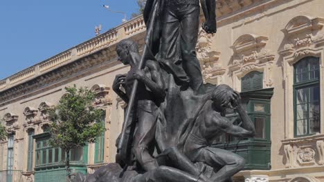 Amazing-tilt-down-shot-of-the-Sette-Giugno-Monument-in-the-historic-city-of-Valletta,-Malta