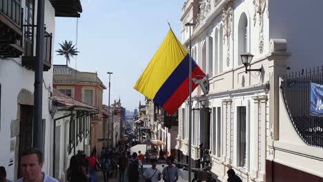 Tourists-explore-narrow-colonial-tourism-street-in-Bogota,-Colombia