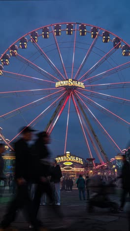 Vertical,-Night-Time-lapse-of-People-Crowd-and-Illuminated-Funfair-Rides-at-Amusement-Park,-Motion-Blur