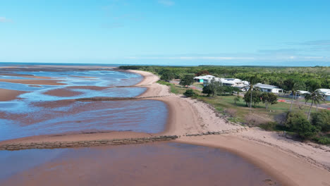 Luftaufnahme,-Spur-Vorwärts,-Die-Küstenlinie-Eines-Strandes-Bei-Ebbe-Mit-Strandhäusern-Und-Blauem-Himmel-Im-Hintergrund,-Waldstrand,-Hoher-Norden-Von-Queensland,-Australien