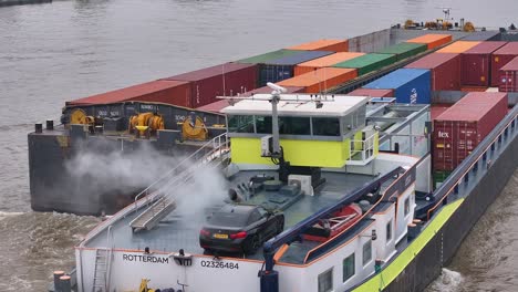 H2-Container-Barge-Loaded-With-Containers-And-Car-Emitting-Smoke-On-River-In-Dordrecht,-Netherlands