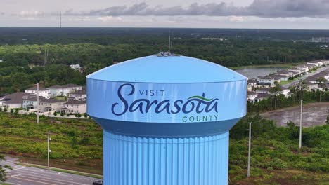 Visit-Sarasota-County-on-Blue-Tower-with-Highway-and-modern-suburb-neighborhood-in-Background