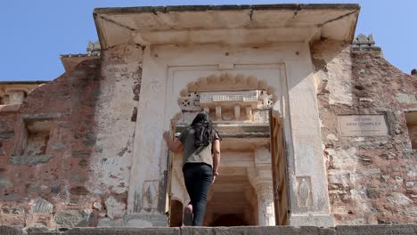 young-girl-at-historic-fort-temple-entrance-at-morning-from-flat-angle