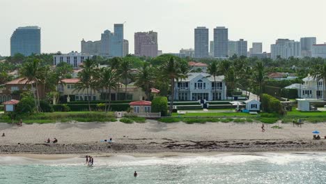 Gente-Descansando-En-La-Playa-De-Arena-Frente-A-Las-Villas-En-West-Palm-Beach-Durante-Un-Día-Soleado