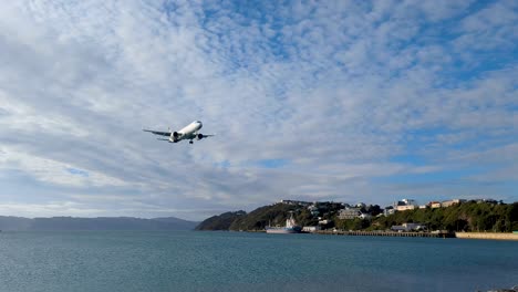 Close-up-of-Air-New-Zealand-airplane-flying-in-over-harbour-water-to-land-at-Wellington-International-Airport-in-capital-city-of-NZ-Aotearoa