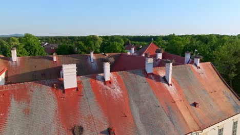 Old-House-Roof-With-White-Storks-Nesting-On-Its-Chimneys-In-Marchegg,-Austria