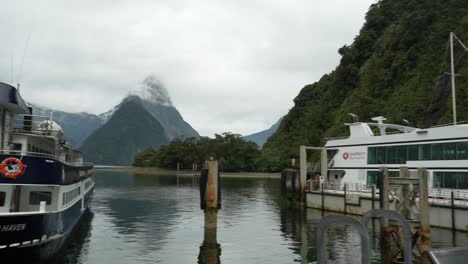 Schwenkansicht-Der-Touristischen-Kreuzfahrtschiffe-In-Der-Milford-Sound-Marina-In-Neuseeland-An-Einem-Nebligen-Tag