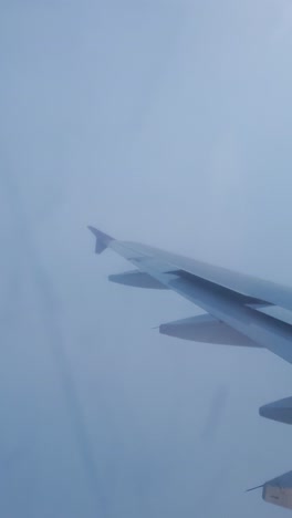 Blick-Aus-Dem-Flugzeug,-Das-Tagsüber-In-Einer-Szene-Mit-Blauem-Himmel-Aus-Dem-Flugzeugfenster-Fliegt