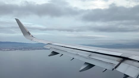 Blick-Aus-Einem-Flugzeugfenster-Auf-Landschaften-Und-Wolken-Von-Hoch-Oben