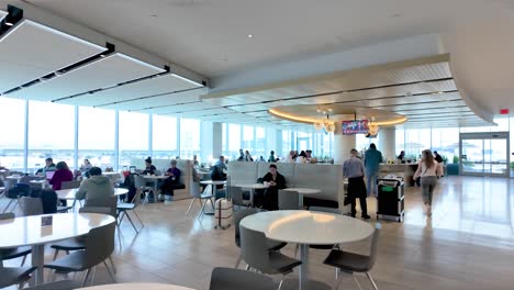 Passagiere-Entspannen-In-Flughafen-Loungesesseln-Und-Laden-Ihre-Geräte-Auf,-Genießen-Speisen-Und-Getränke-In-Der-Flughafen-Lounge