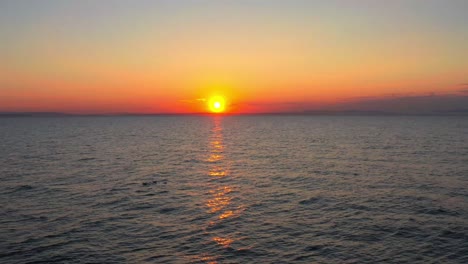 Drohne-über-Möwen,-Die-In-Der-Nordsee-Am-Strand-Von-Findhorn-Schweben,-Mit-Rotem-Sonnenuntergang-In-Schottland,-Luftaufnahme