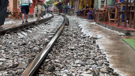 Hanoi-Bahnstraße,-Vietnam---Menschen-Betreten-Gleise,-Niedriger-Winkel,-Top-10-Touristenziel