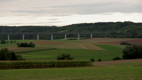 High-speed-train-crossing-a-tall-bridge-over-a-scenic-rural-landscape