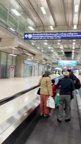 Blick-Vom-Flughafen.-Viele-Leute-Kommen-Mit-Gepäck-In-Den-Händen-Auf-Der-Rolltreppe-Zum-Flughafen.